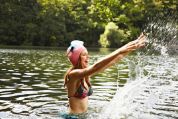 frau-mit-taucherbrille-auf-kopf-im-fluss-stehend frau-mit-taucherbrille-auf-kopf-im-fluss-stehend